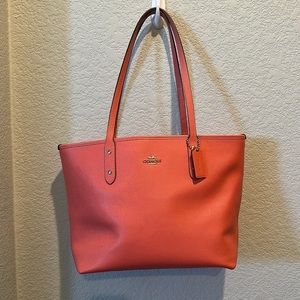 Salmon colored Coach purse.